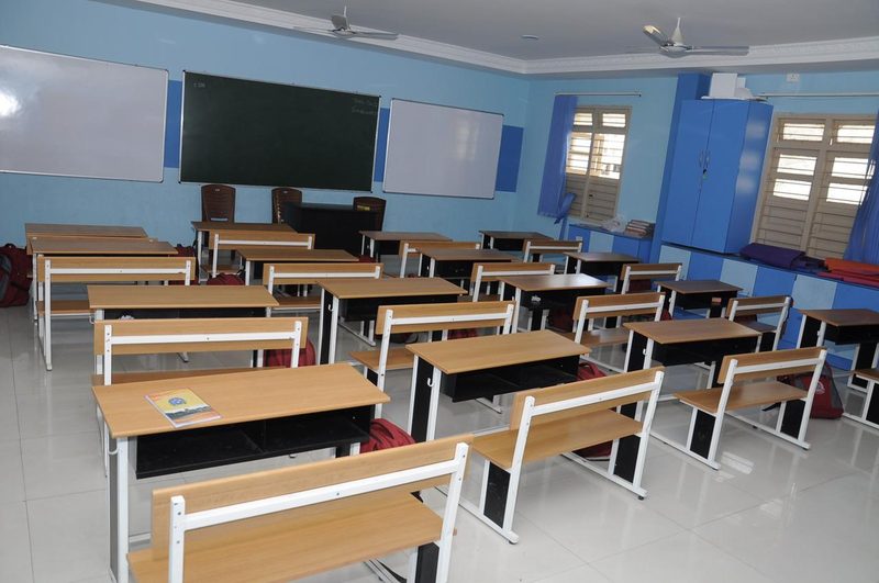 Rows of classroom desks and benches installed in a Coimbatore school