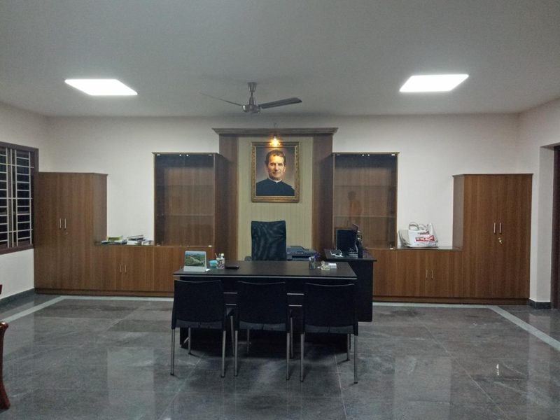 Director's cabin with full-wall wooden storage and display units in a Coimbatore office